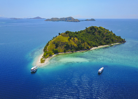 Aerial view of beautiful scenery at Flores island with tourist yatch, turqouise and dark blue seaの写真素材