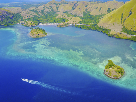 Aerial view of beautiful scenery at Flores island with tourist yatch, turqouise and dark blue seaの写真素材