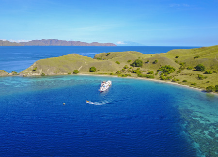Tourist boat passing over Gili Lawa Island, aerial viewの写真素材