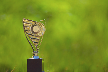 Gold trophy isolated on green nature bokehの写真素材