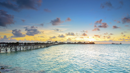 Long bridge heading to beautiful resort at Mabul Island during sunsetの写真素材