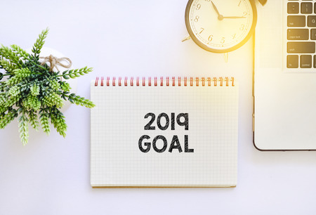 2019 Goal word on blank notepad with black alarm clock and laptopの写真素材