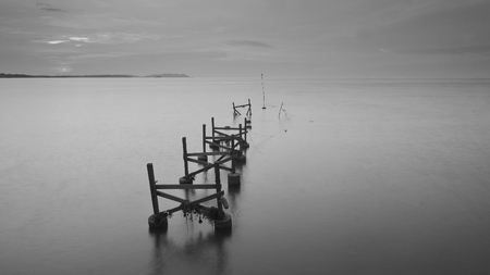 Long exposure shot of old broken jetty during pastel sunsetの写真素材
