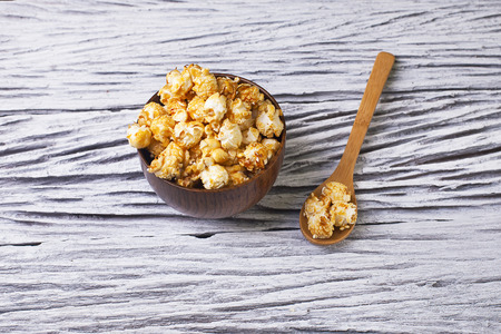 Caramel popcorn in the bowl wooden backgroundの写真素材