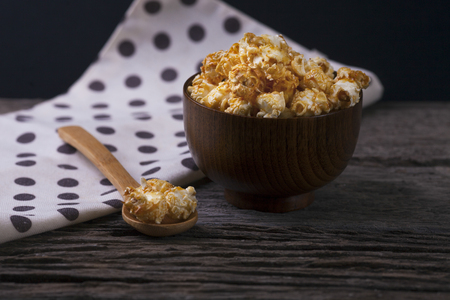 Caramel popcorn in the bowl wooden backgroundの写真素材