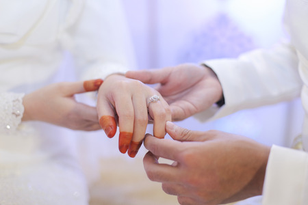 Groom put ring on bride handの写真素材