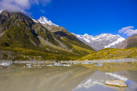 Tasman Glacier Lake with giant floating icebergs, Aoraki Mount Cook National Park New Zealand. Mt Cook looming in the cloudsの写真素材