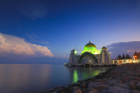 Blue hour at beautiful Malacca Straits Mosque with moon at backgroundの写真素材