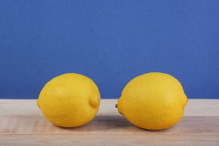 Fresh lemon fruit on wooden and blue backgroundの写真素材
