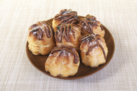 Chocolate cream puff on wooden backgroundの写真素材