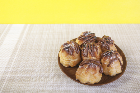 Chocolate cream puff on wooden backgroundの写真素材