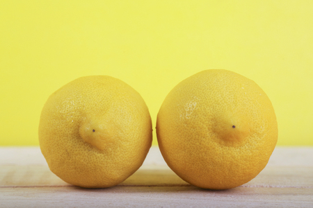 Fresh lemon fruit on wooden and yellow backgroundの写真素材