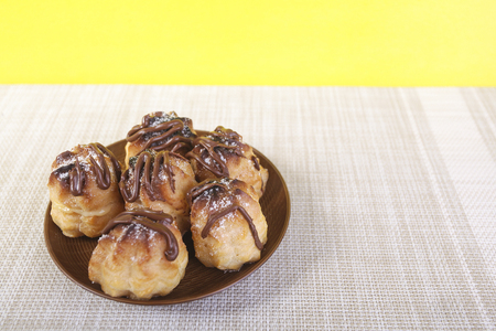 Chocolate cream puff on wooden backgroundの写真素材