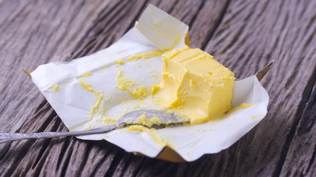 Butter and spoon on wooden backgroundの写真素材