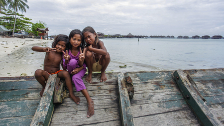 Semporna Sabah, Malaysia - July 18, 2017: Scene at Mabul Island. Sea Gypsy kids on a handmade canoes in Bodgaya Mabul Sipadan Island, Sabah Borneo, Malaysiaのeditorial素材