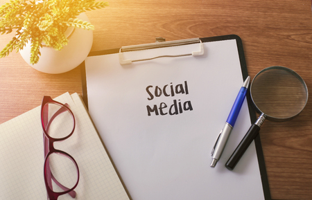 Social Media word on paper with glass ballpen and green plantの写真素材