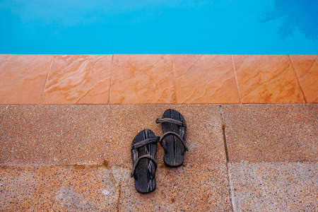 Holiday time. Sandal beside the swimming poolの写真素材
