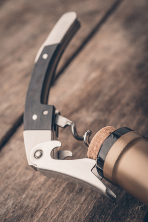 Corkscrew and bottle of wine on the boardの写真素材