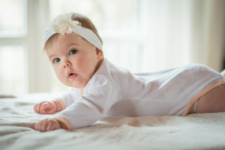Baby girl lying on blanketの写真素材
