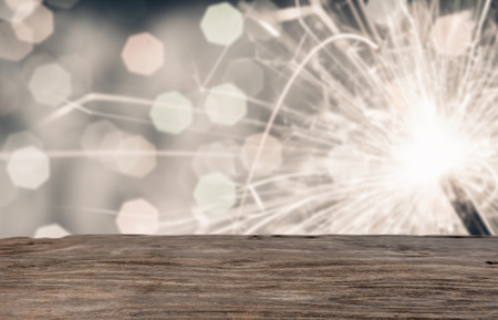 Empty rustic wood good for montage or display product for holidays with sparkler in backgroundの写真素材