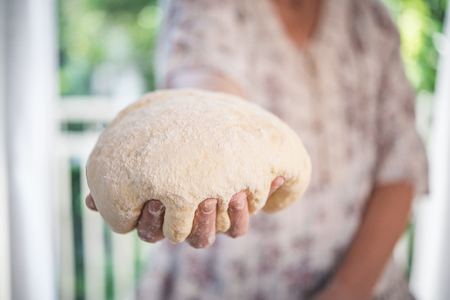 Bread dough hold by handの写真素材