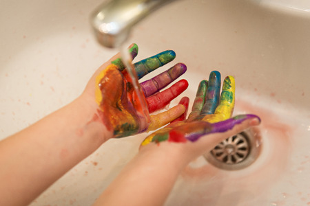 Child washing dirty hands of paintの写真素材