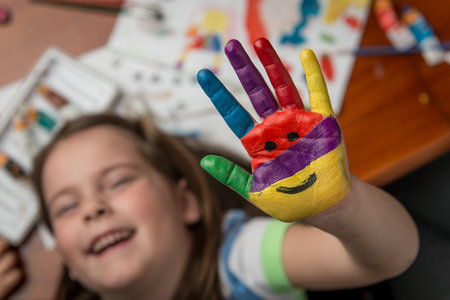 Smailing caucasian girl with paintd handの写真素材