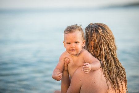 Young mother and cute little girl are enjoying on exotic beachの写真素材