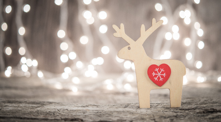 Vintage wooden christmas ornament over blurred lights backgroundの写真素材