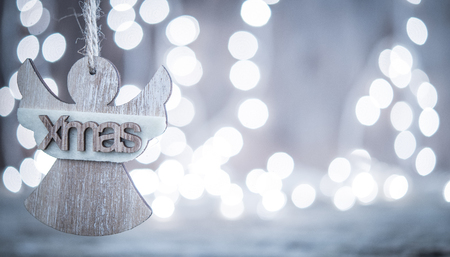 Christmas card with wooden angel and bokeh lihgts backgroundの写真素材