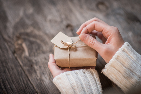 Female's hands opening gift box as holiday backgroundの写真素材