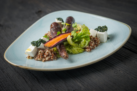 Vegan dish in plate on rustic wooden table, purple carrot with kinoaの写真素材