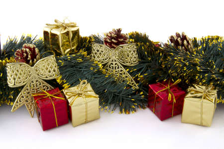 arrangement of Christmas decorations (gifts, tinsel, cones, ribbons) on a white backgroundの写真素材