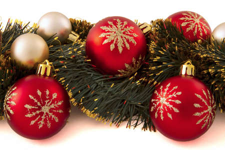 arrangement of Christmas decorations (red and gold balls, tinsel) on a white backgroundの写真素材