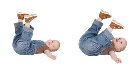 child is lying with lifted legs on a white backgroundの写真素材