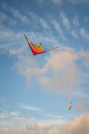 colorful kite tangled in Electrical wires against the evening skyの写真素材