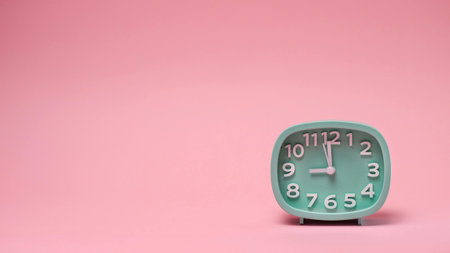 Green alarm clock on pink background. Copy space. Time concept.の写真素材