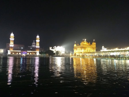 Sri Harimandir sahib, Amritsar scenic view at night with beautiful lake water rippling.の素材