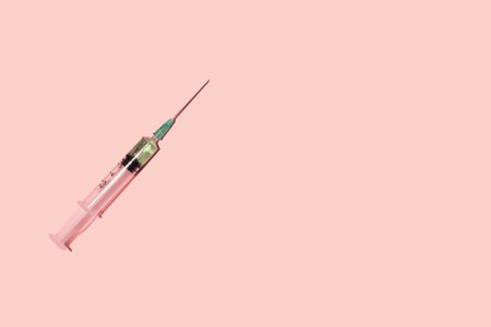 Syringe on pastel pink background.の写真素材
