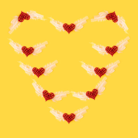 Hearts with angel wings  make heart shape.Minimal Love concept ,flat lay yellow background.