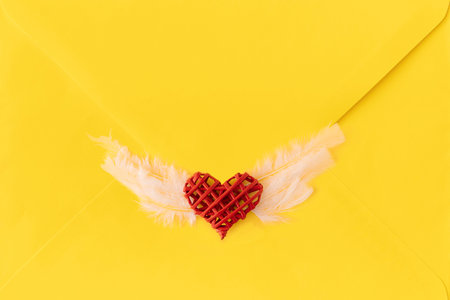Seal make of angel heart with wings.Unique stamp on yellow letter.Minimal love concept ,flat lay.の写真素材