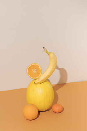 Fruit still life against beige background.Melon, Banana,Tangerine and Orange.Minimal concept