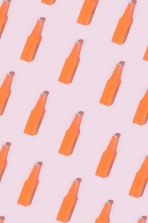 Pattern made with red bottle of cocktails against pastel pink background.Minimal summer concept of sunny day.の写真素材