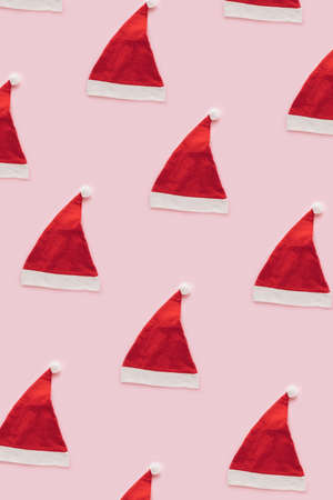 Santa claus cap Christmas pattern against pastel pink background. Minimal new year concept.の写真素材