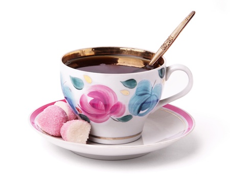 A vintage china gold cup of tea whith sweets on a white backgroundの写真素材