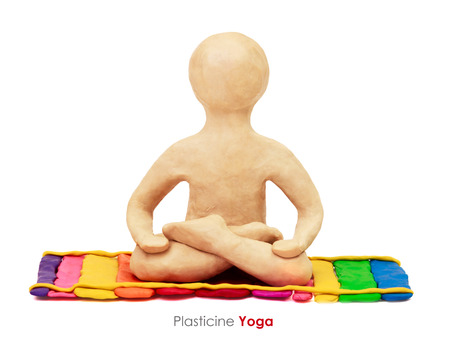 Plasticine man sitting in maditation yoga lotus posture on white backgroundの写真素材