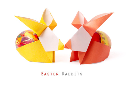 Easter handmade bunny rabbits with painted egg on a white backgroundの写真素材