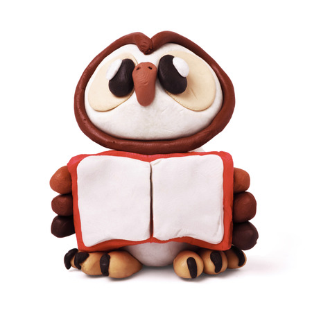 Plasticine cartoon education isolated owl  with book on a white backgroundの写真素材