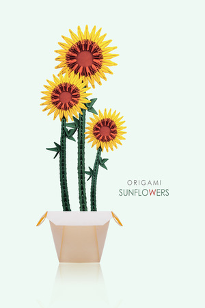 Origami paper sunflowers in a pot on a green backgroundの写真素材