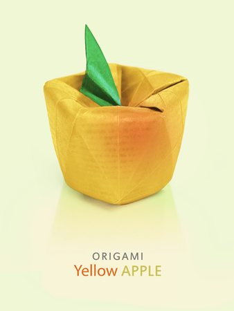 Origami yellow red paper vegetarian symbol art apple on green backgroundの写真素材
